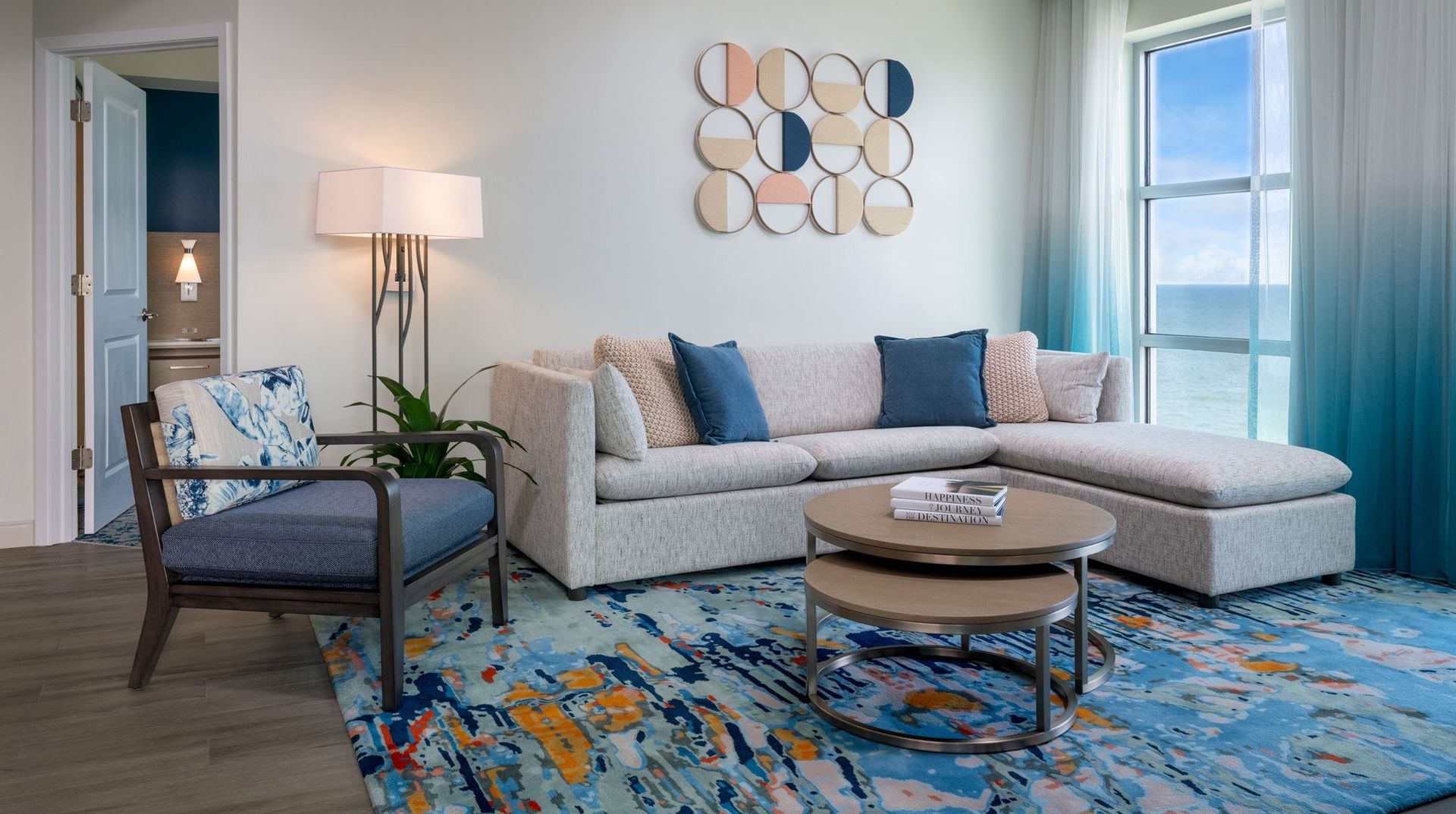 A living room with a couch , chairs , coffee table and rug.