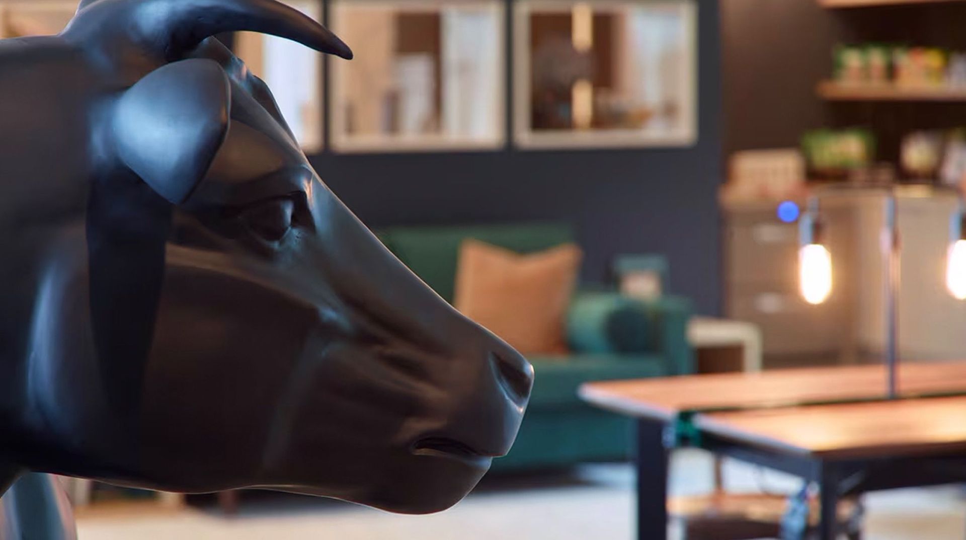 A close up of a black cow statue in a living room.