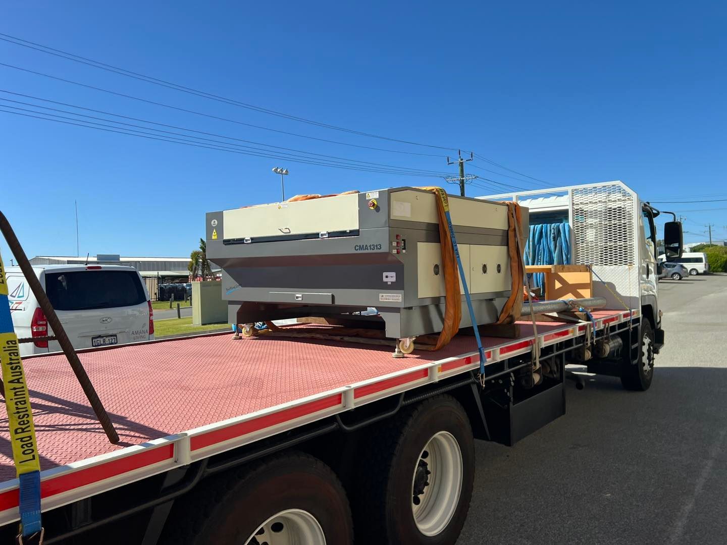 A flatbed truck is carrying a large piece of equipment
