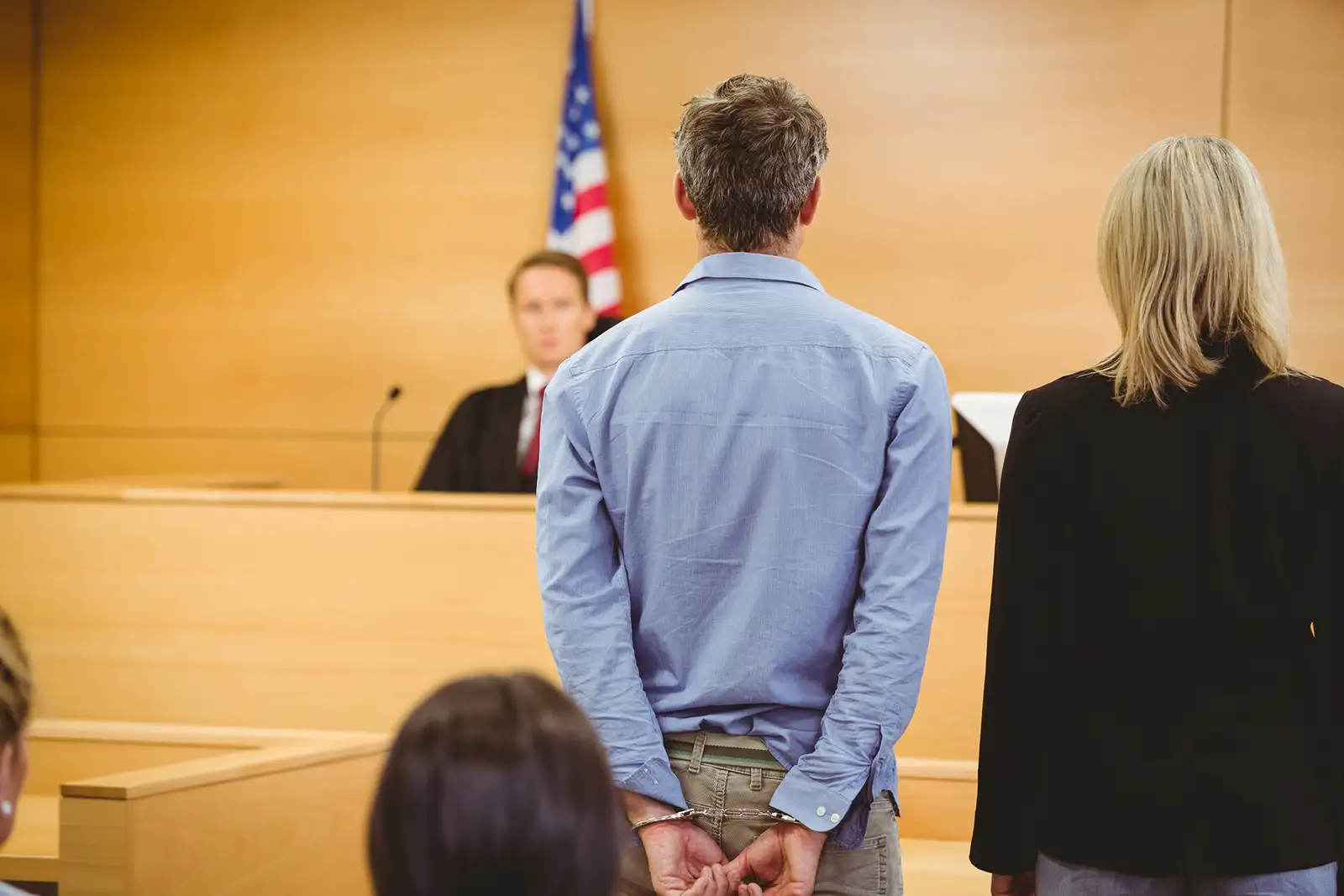 A man in handcuffs in court, representing the topic of felonies in criminal defense law.