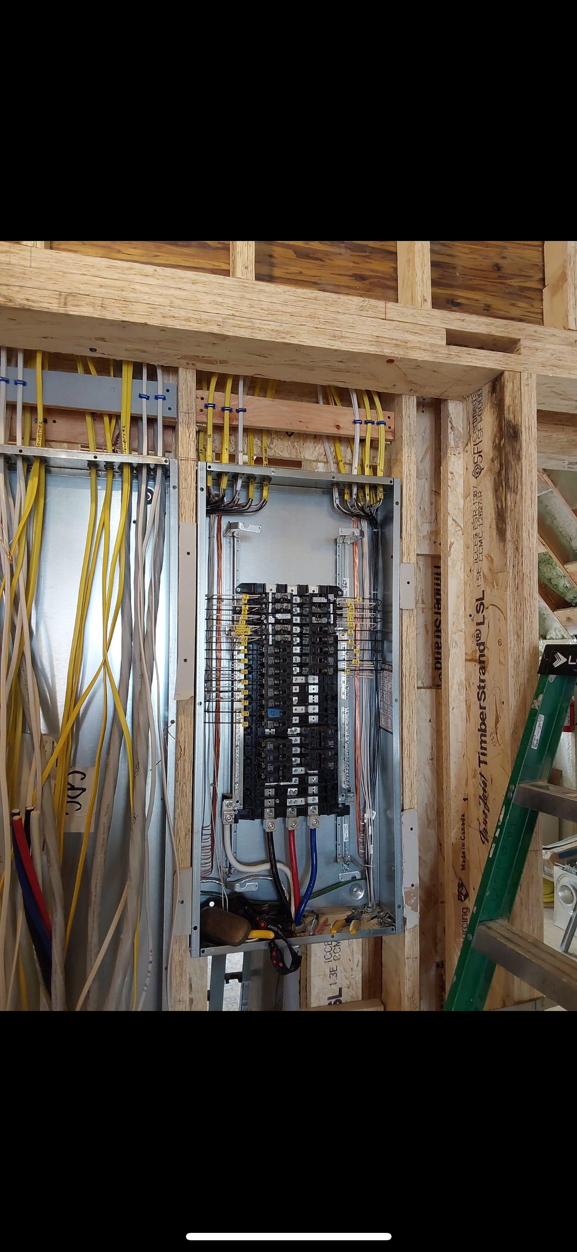 A picture of a electrical box in a house under construction.