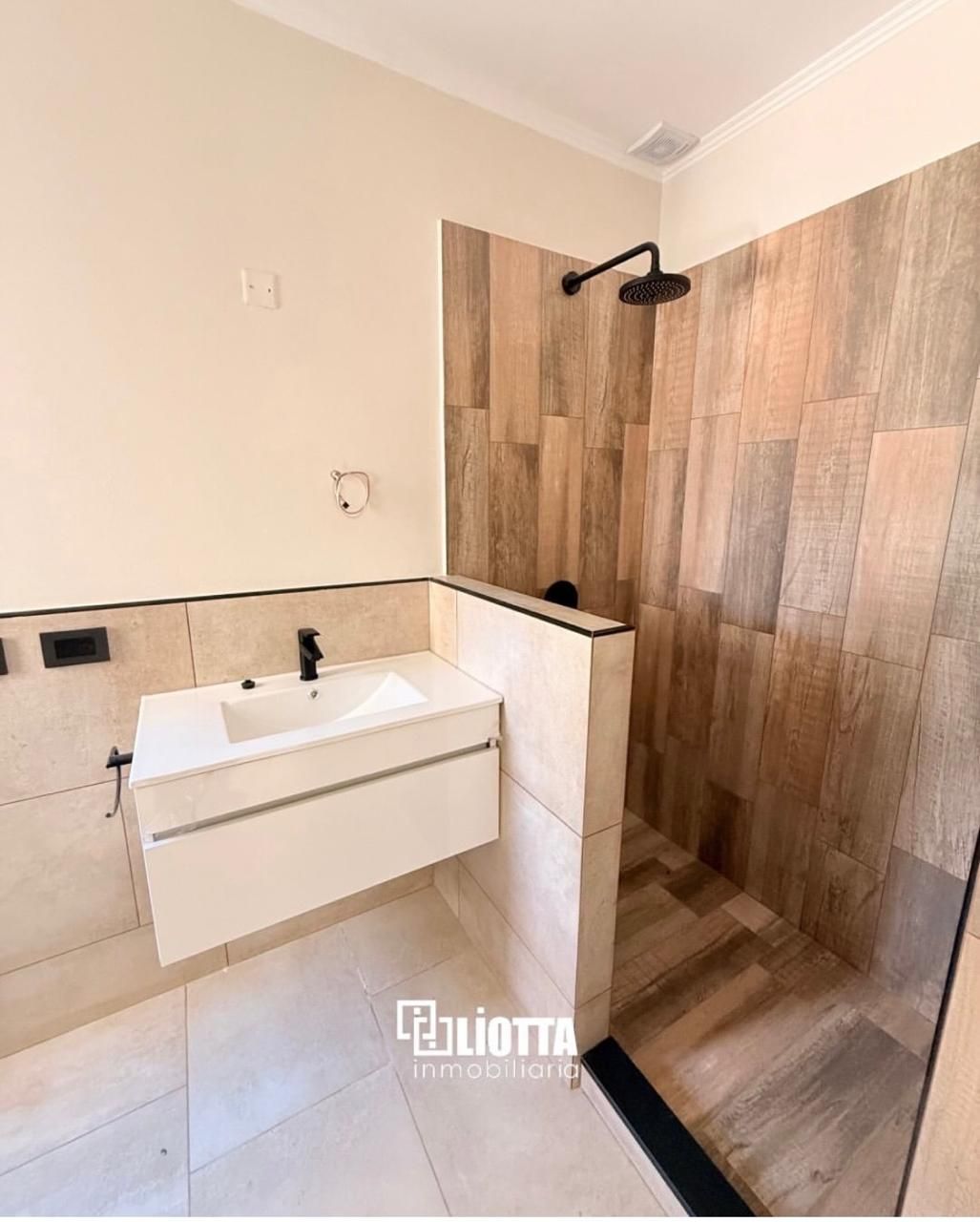 Casa moderna, blanca, con garaje y puerta de entrada, bajo un cielo azul claro.