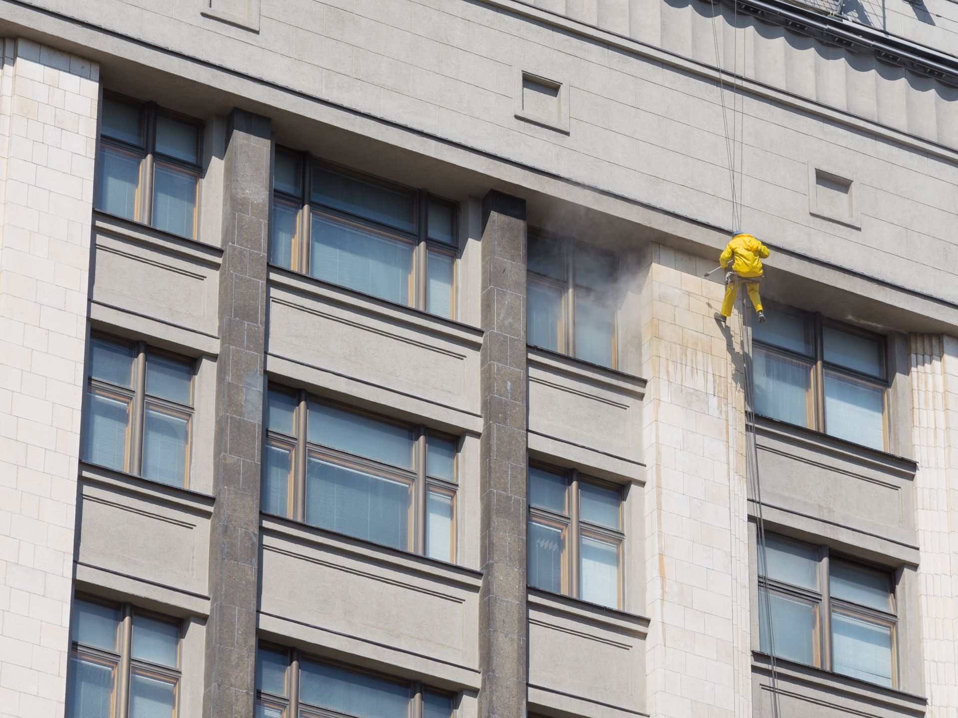 A yellow object is hanging from the side of a building