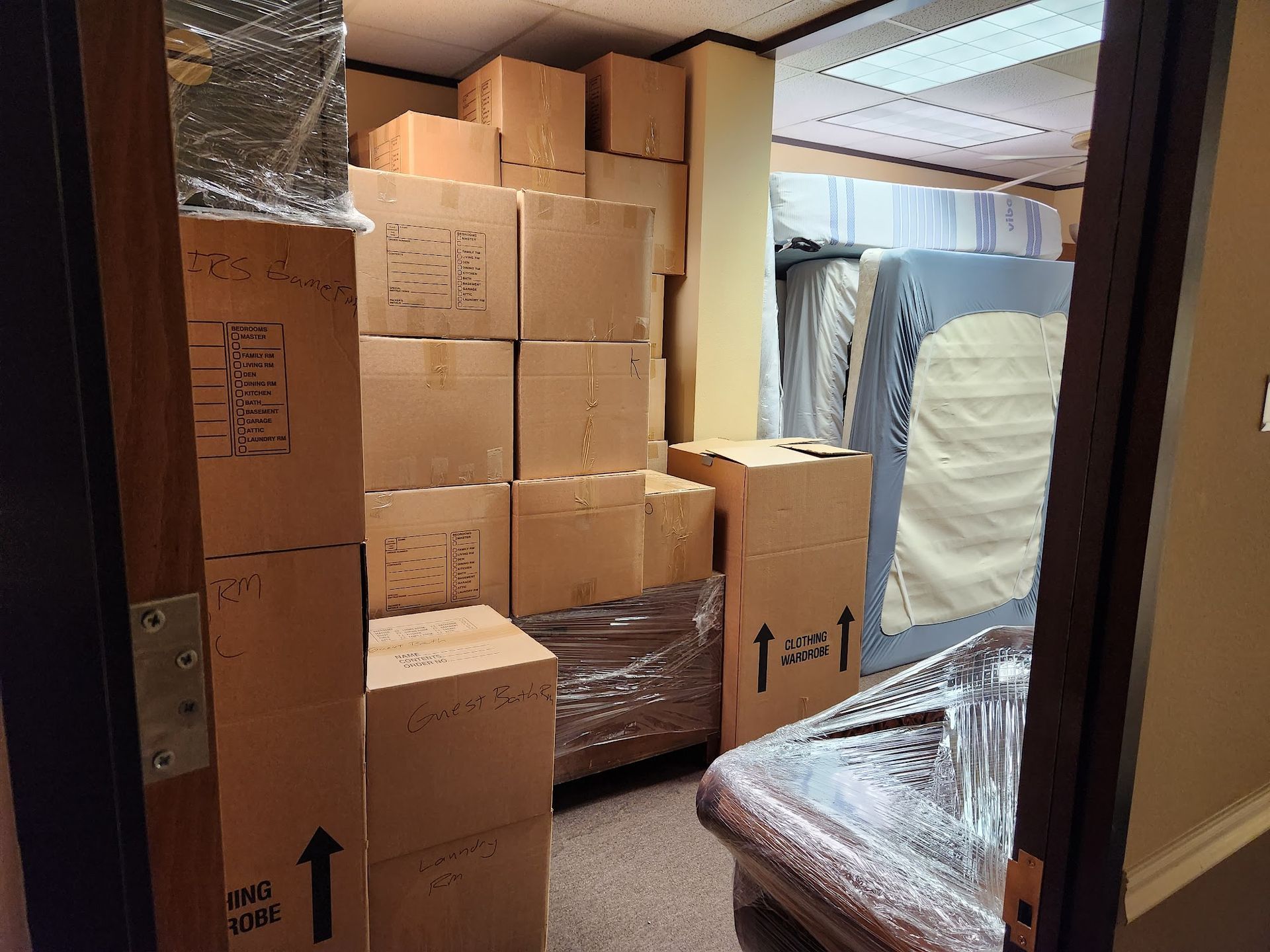 A room filled with lots of cardboard boxes and a couch.