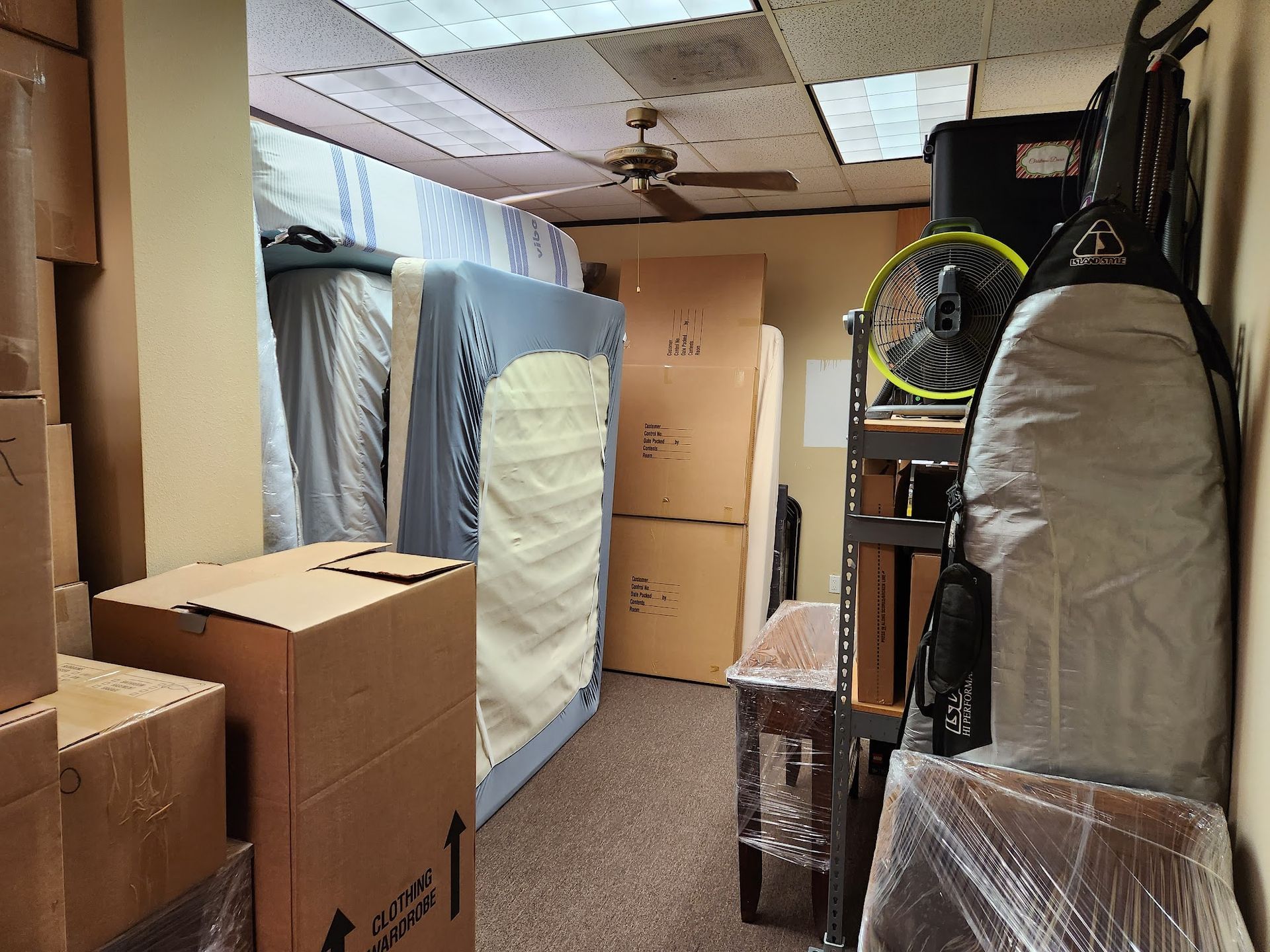 A room filled with boxes and a mattress.