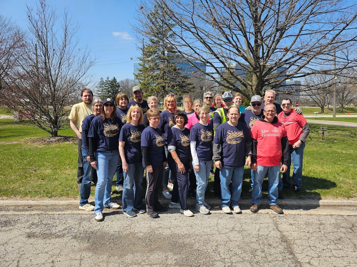A group of people are posing for a picture in front of a tree.