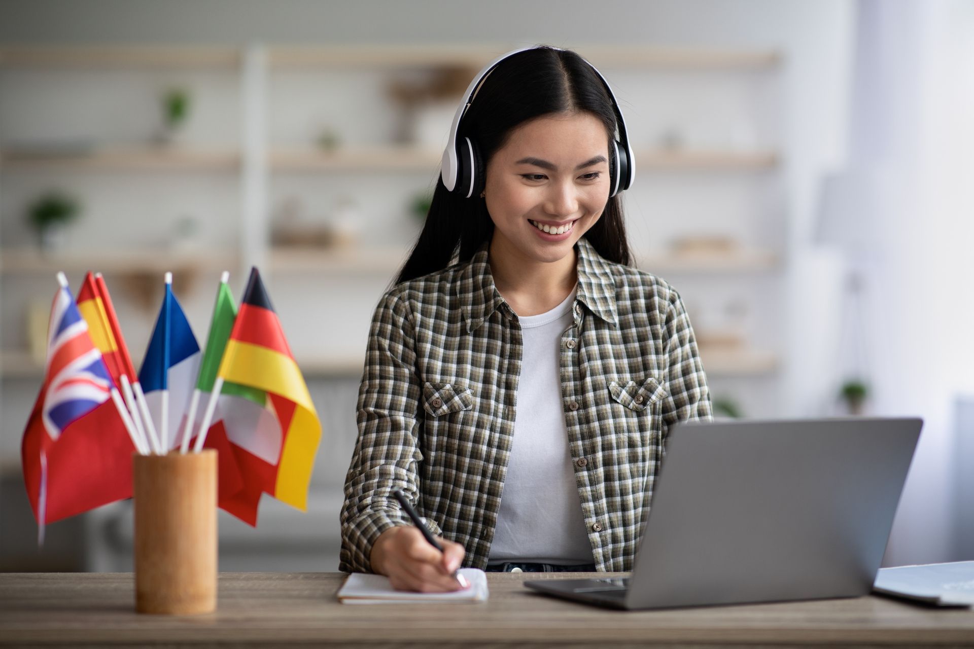 female with headphones learning a new language on the her laptop