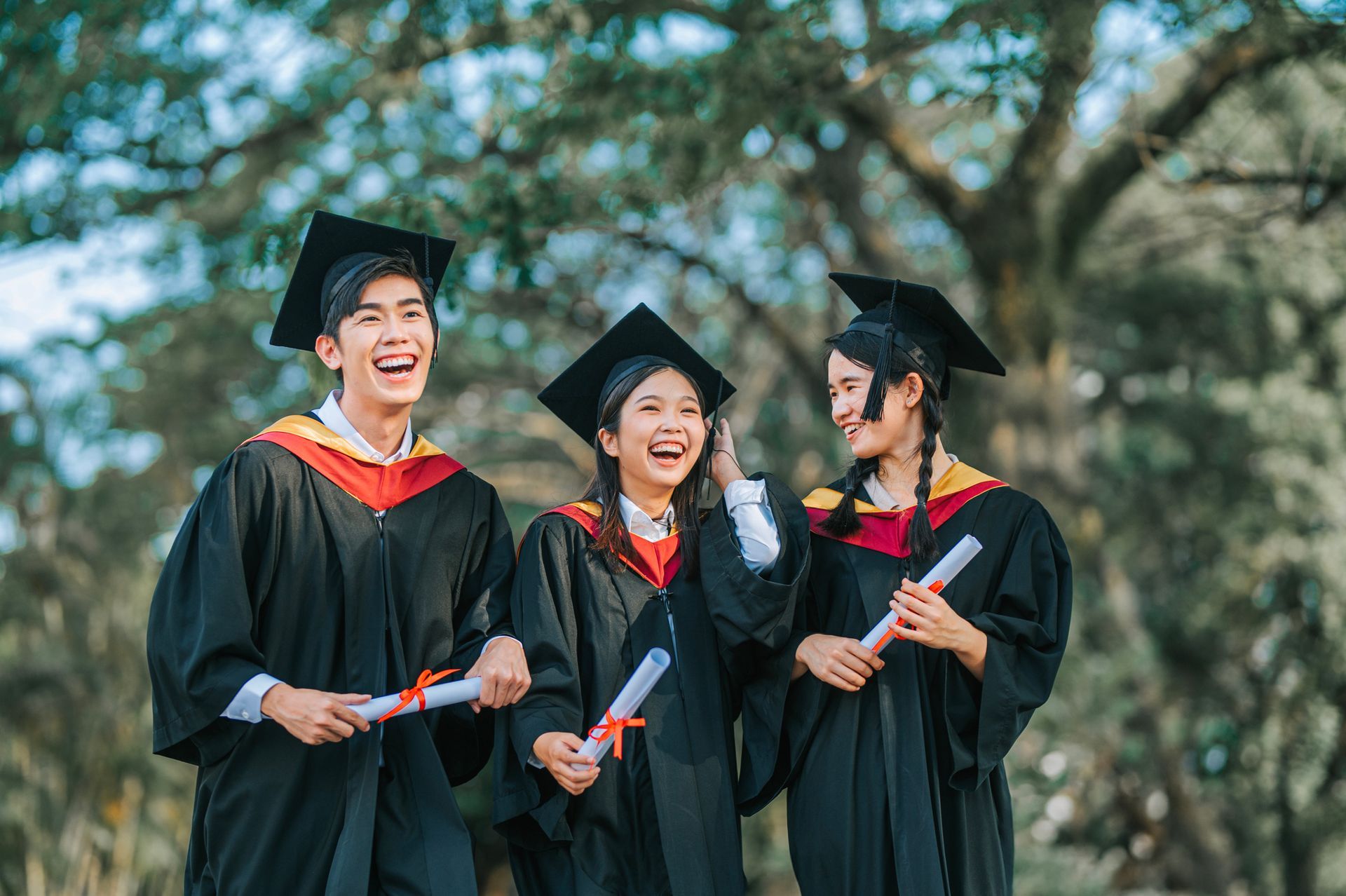 three graduates celebrating together with joy