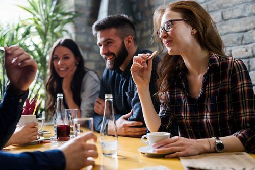 A group of people are sitting at a table in a restaurant having a conversation.