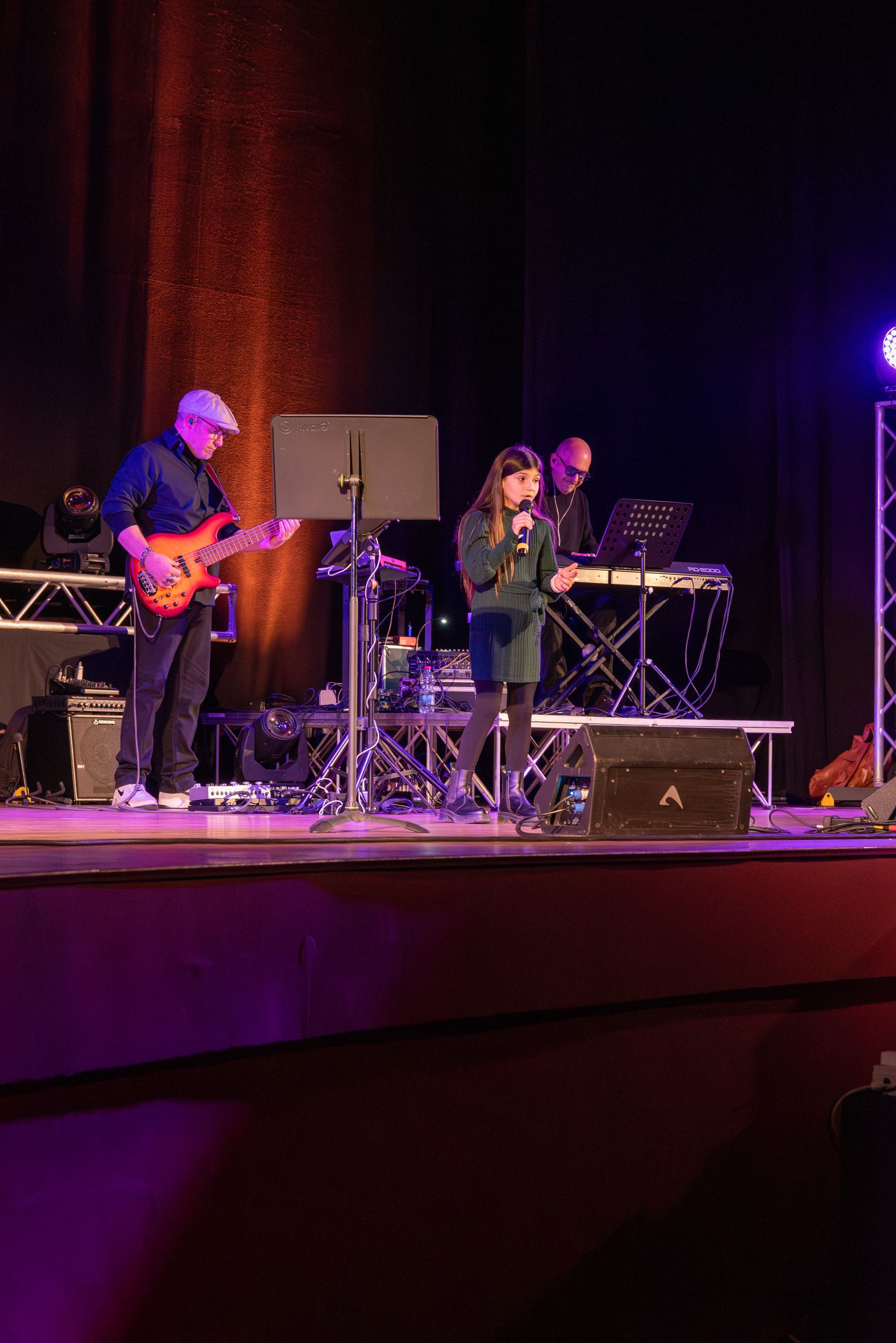 Un uomo suona la chitarra e una donna canta su un palco.
