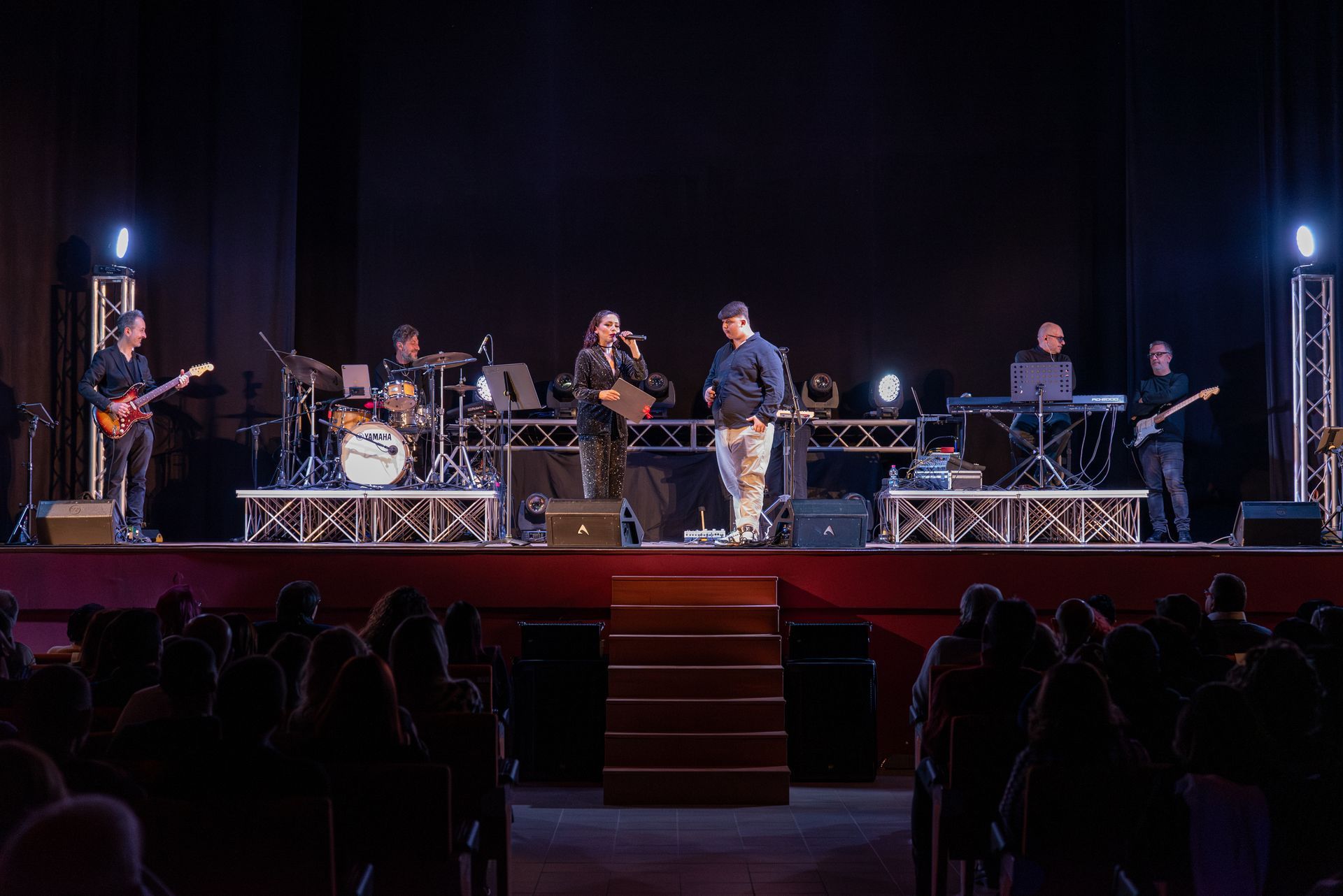 Una band suona su un palco davanti a una folla.