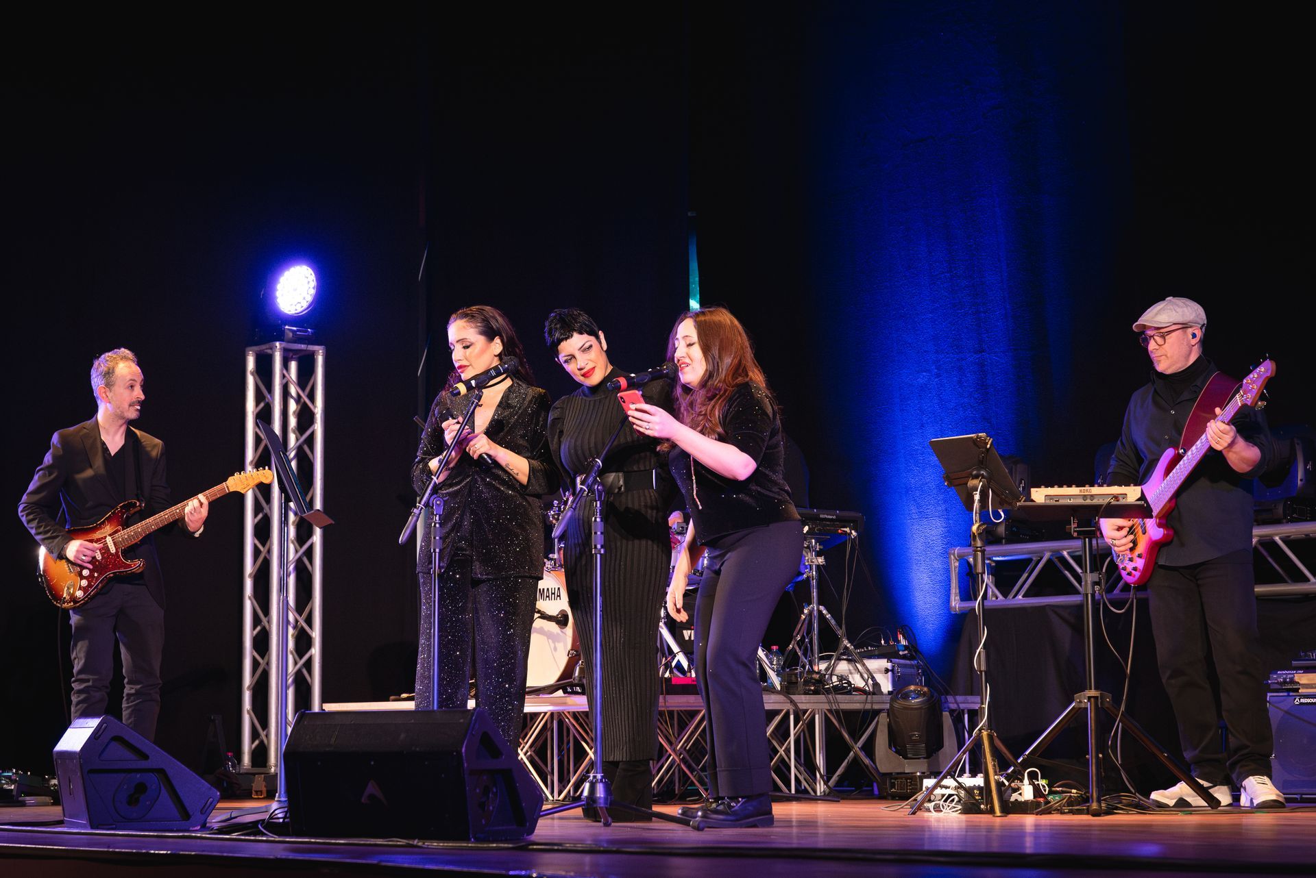Un gruppo di persone sta suonando degli strumenti su un palco.