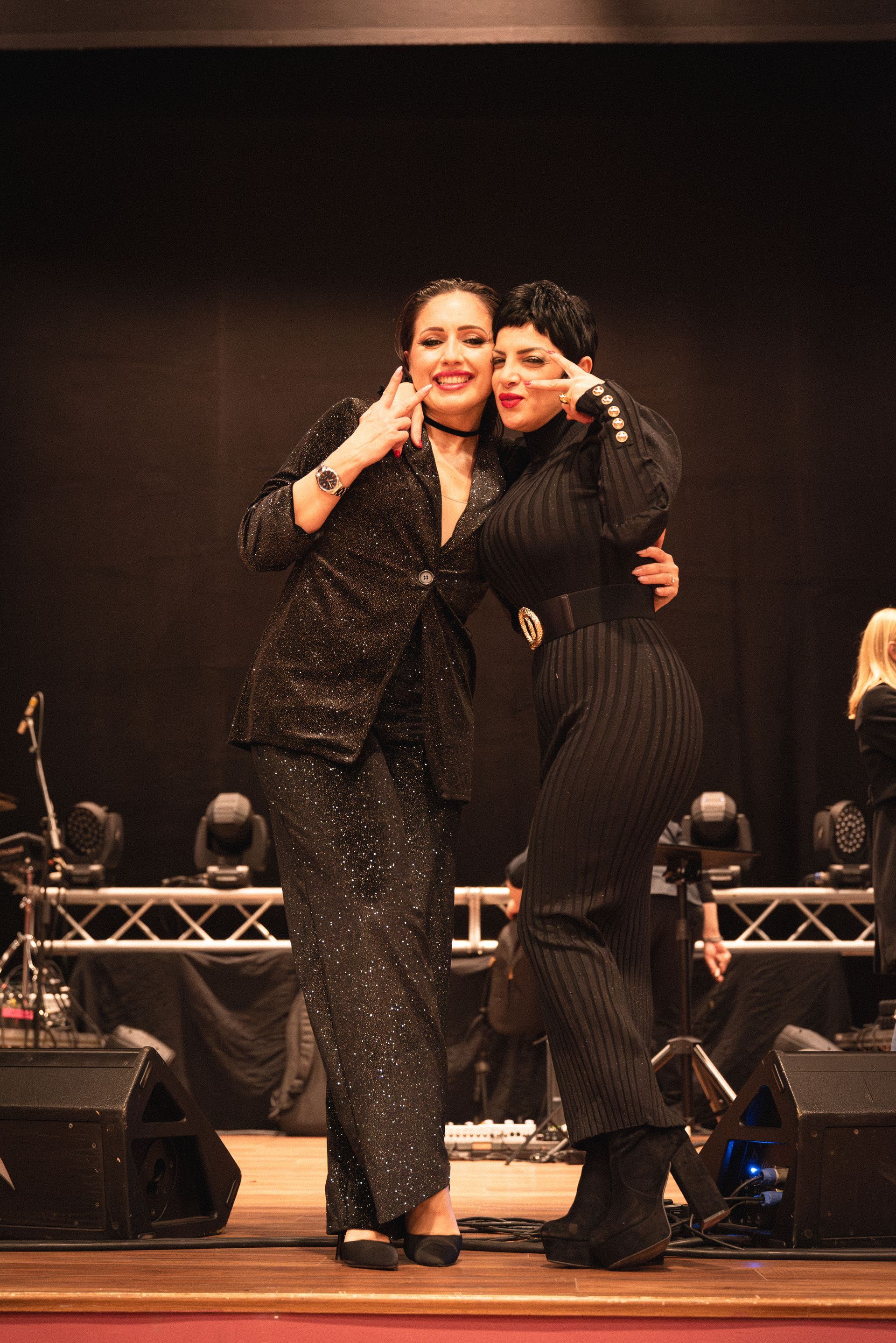Due donne posano per una foto su un palco.