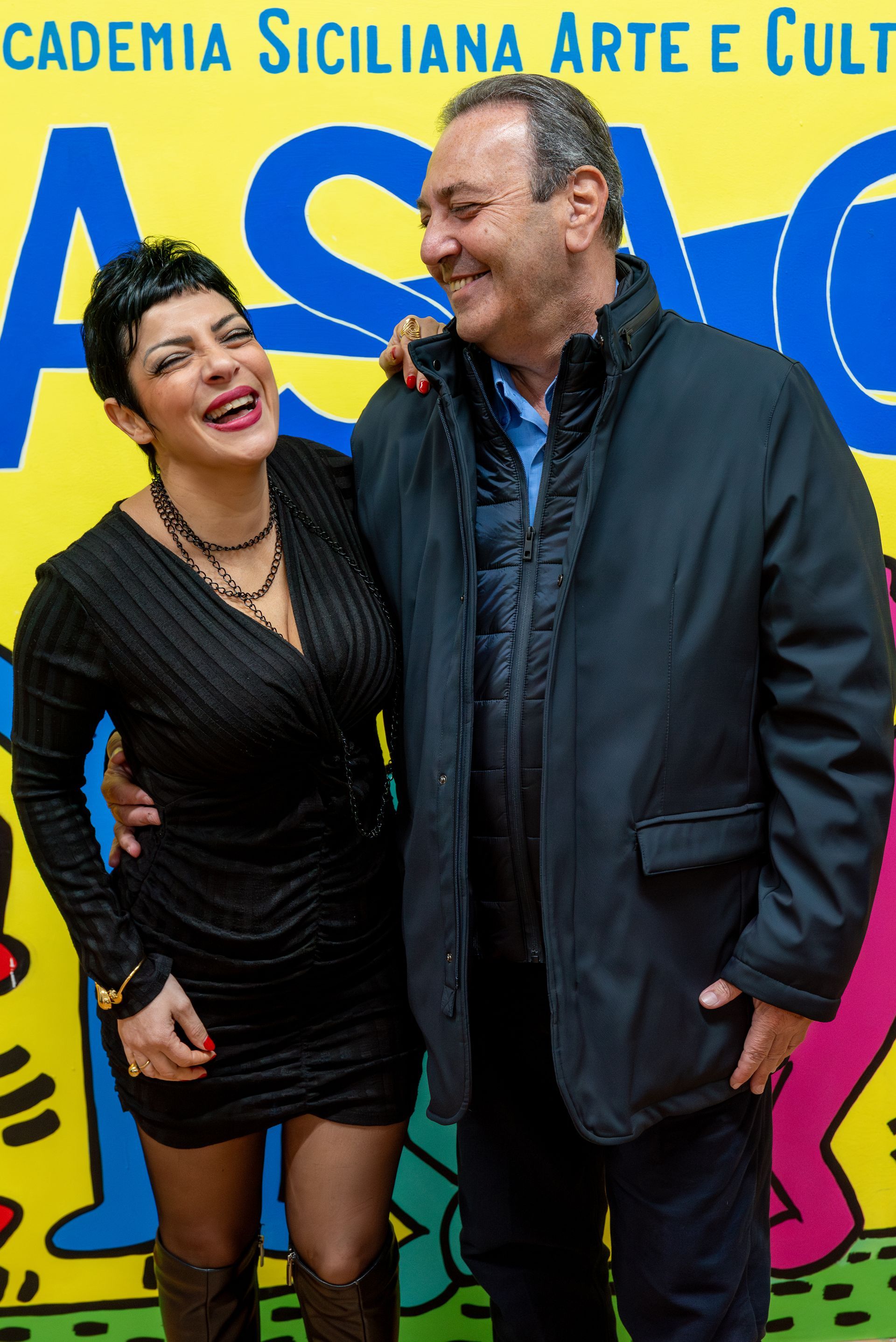 Un uomo e una donna posano per una foto davanti a un cartello che dice cademia siciliana arte e cult