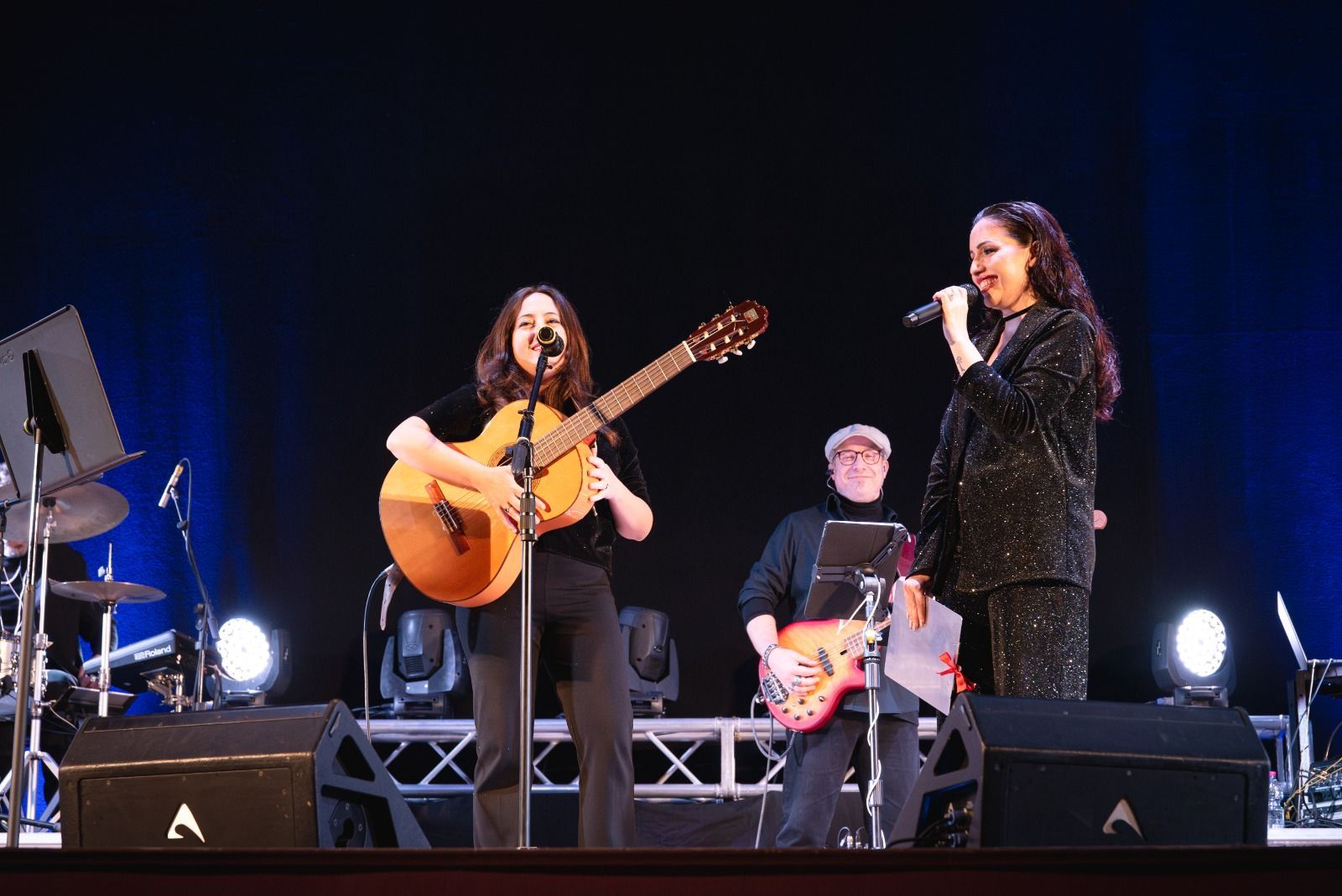 Una donna canta in un microfono su un palco.