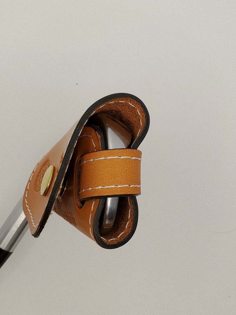 Tan leather cover, stitched, with a snap closure.