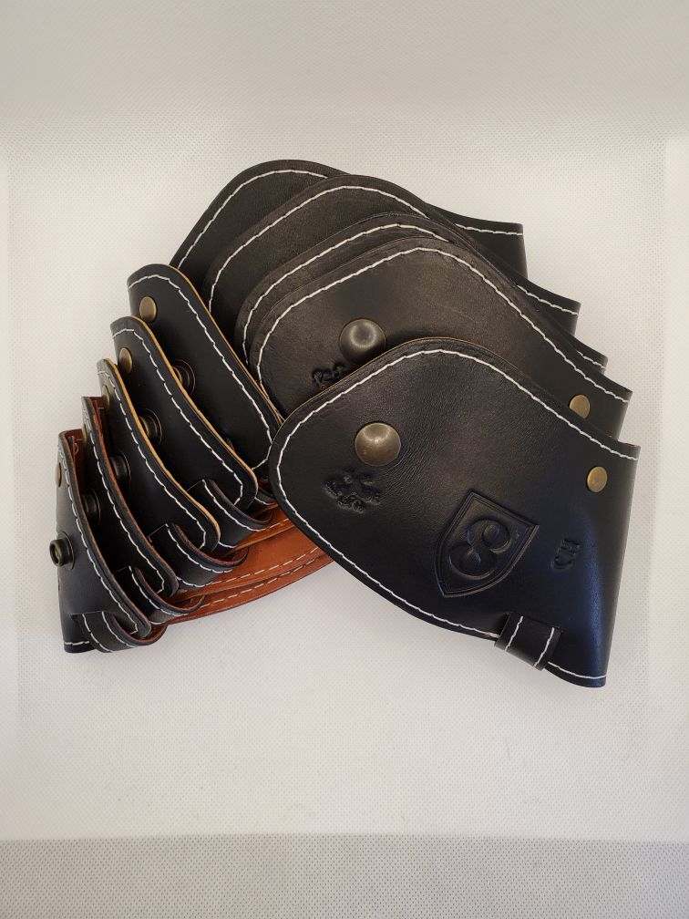 Black leather arm ClubShields with white stitching, brown underside, on a white surface.