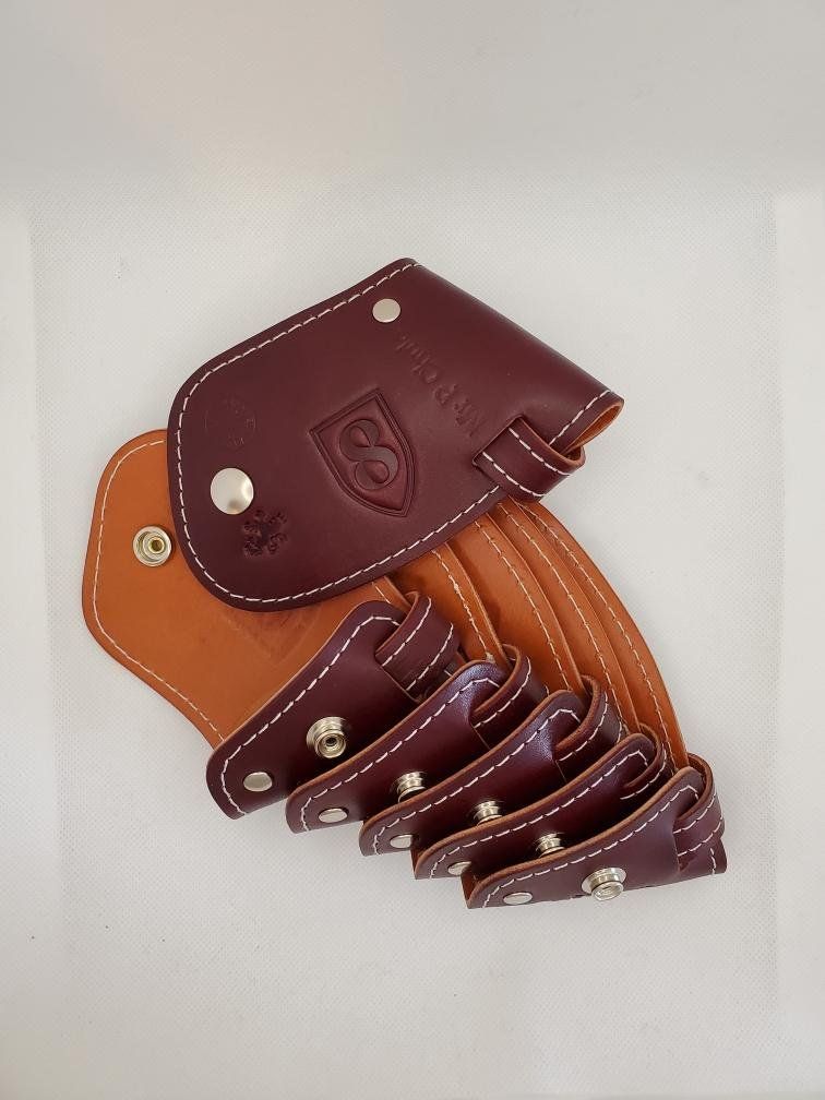 Leather golf head cover, burgundy and tan, with snaps and logo.