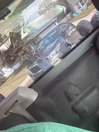 A dark blue van with a pop-up roof parked on a residential street.