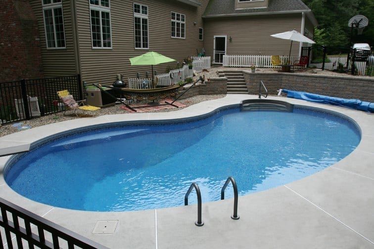 Kidney shaped inground pool with thermoplastic stair and swim out