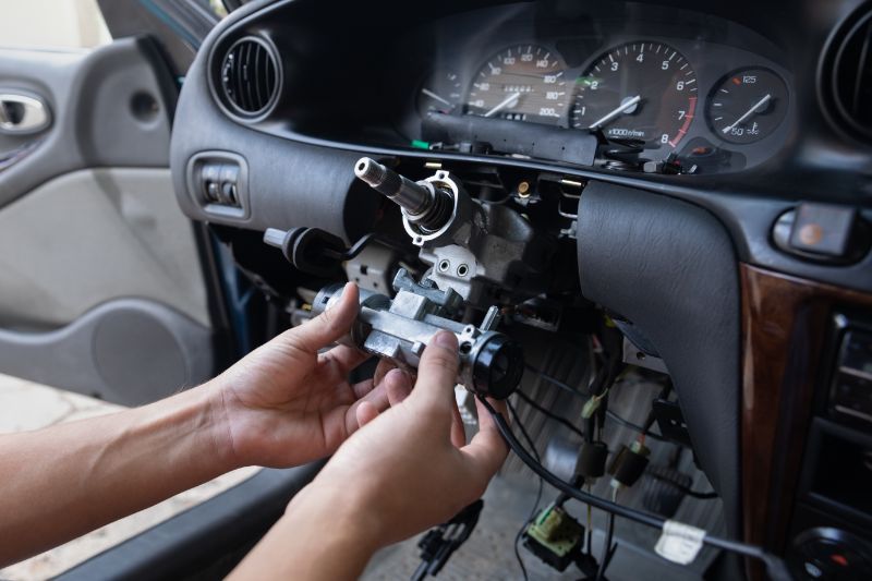 Hands removing a car dashboard radio panel during vehicle repair