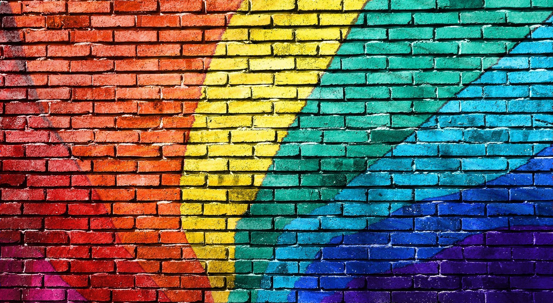 Rainbow-colored brick wall, with bands of red, orange, yellow, green, blue, and purple.