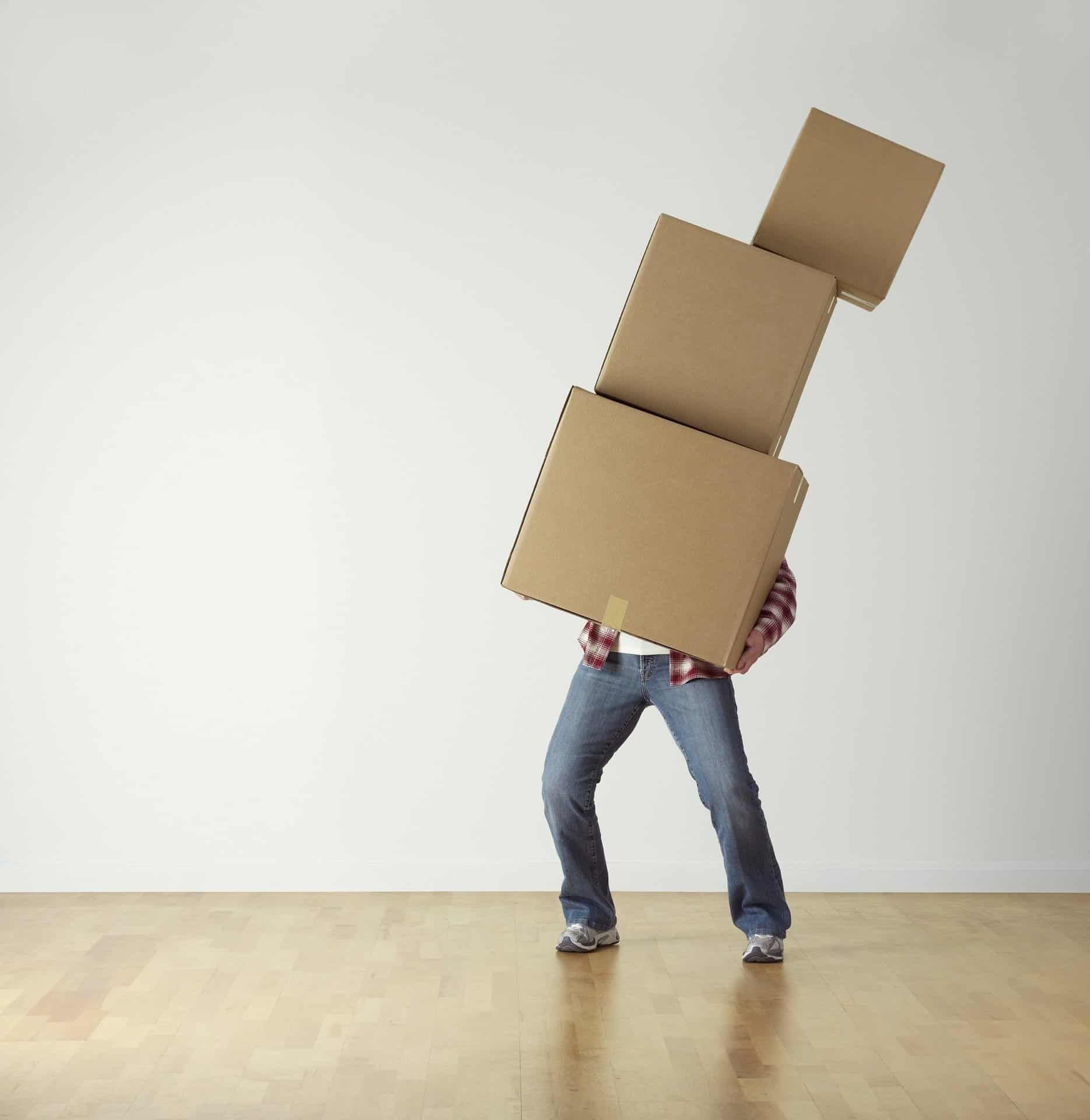 Person carrying three unbalanced cardboard boxes.