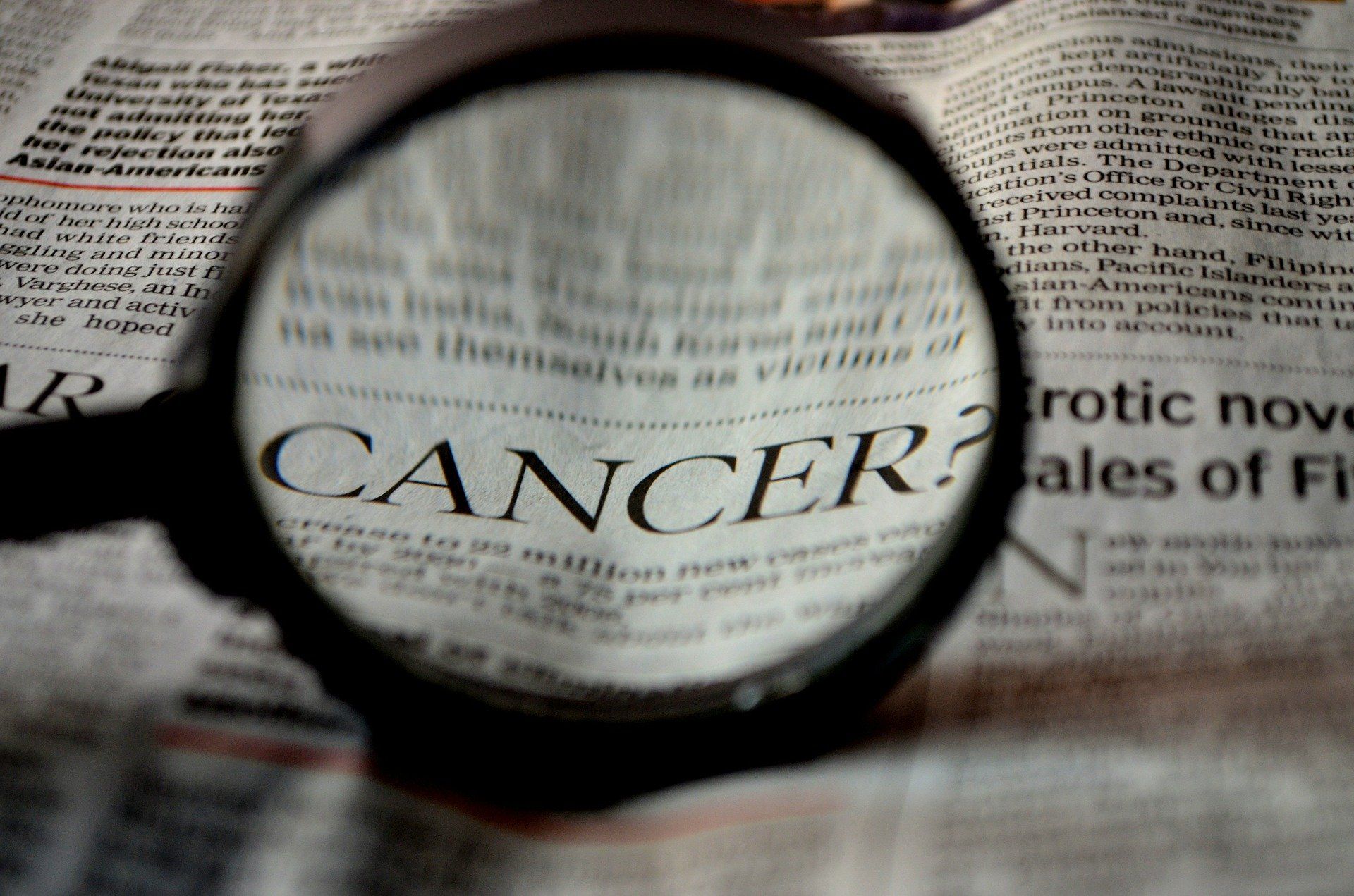 Magnifying glass over newspaper, text reading 