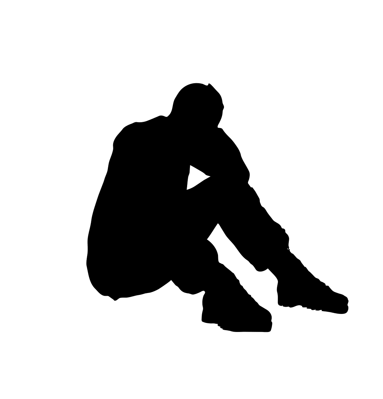 Silhouette of person sitting, head in hand, looking down.