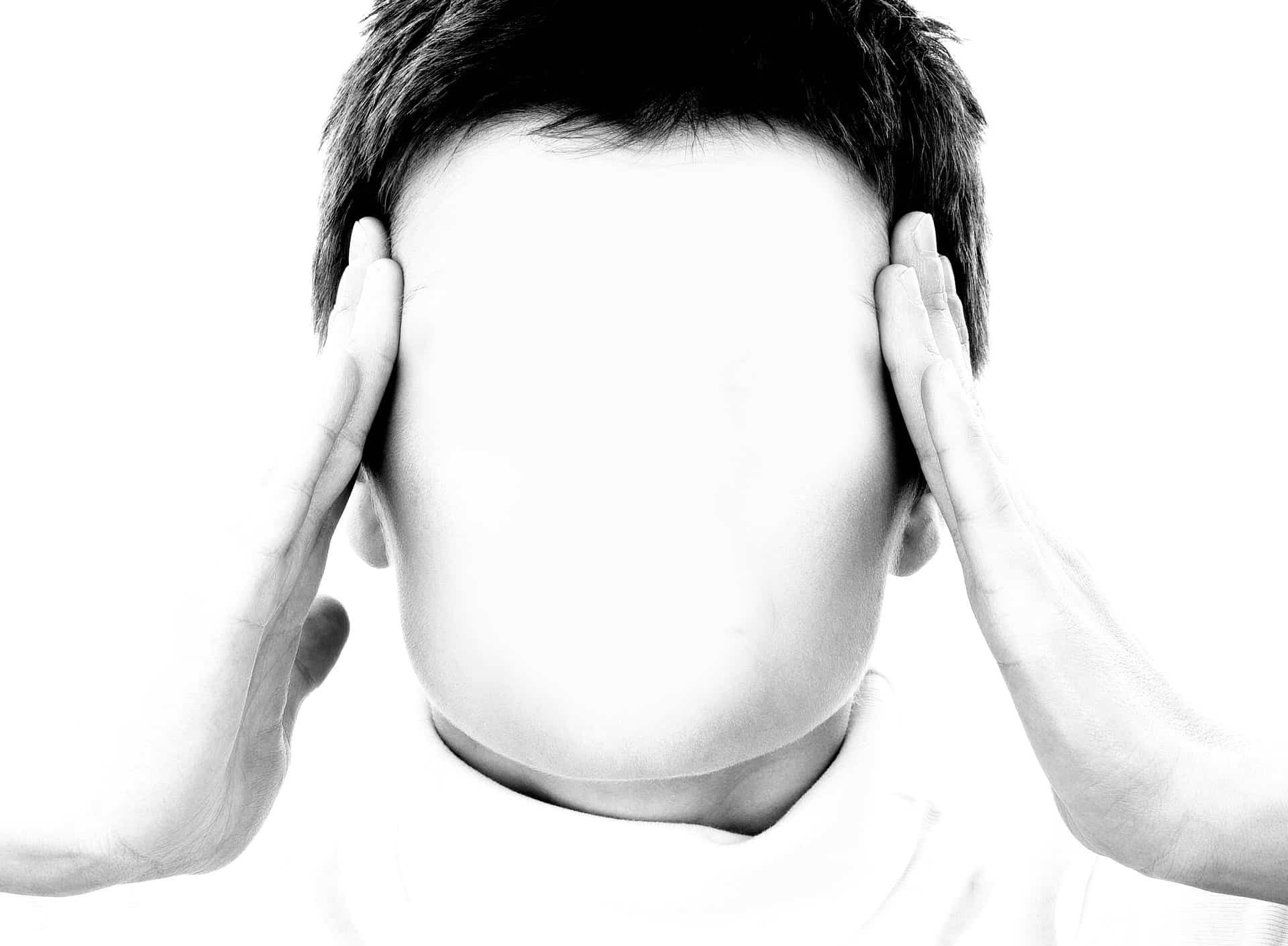 Person, face blank, holding temples with both hands, black and white.