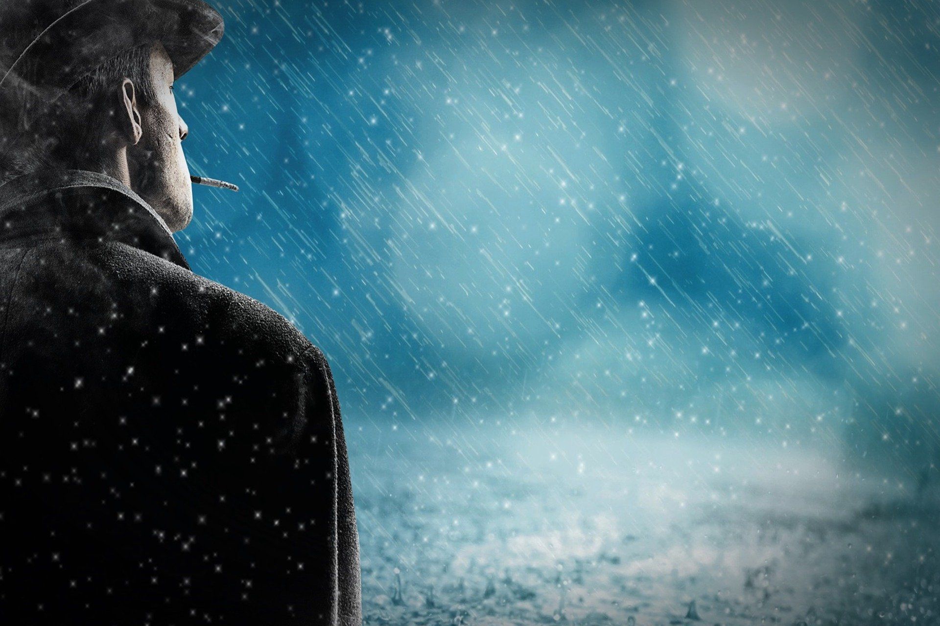 Man in a hat and coat stands in the rain, smoking, looking off at a blurred blue sky.