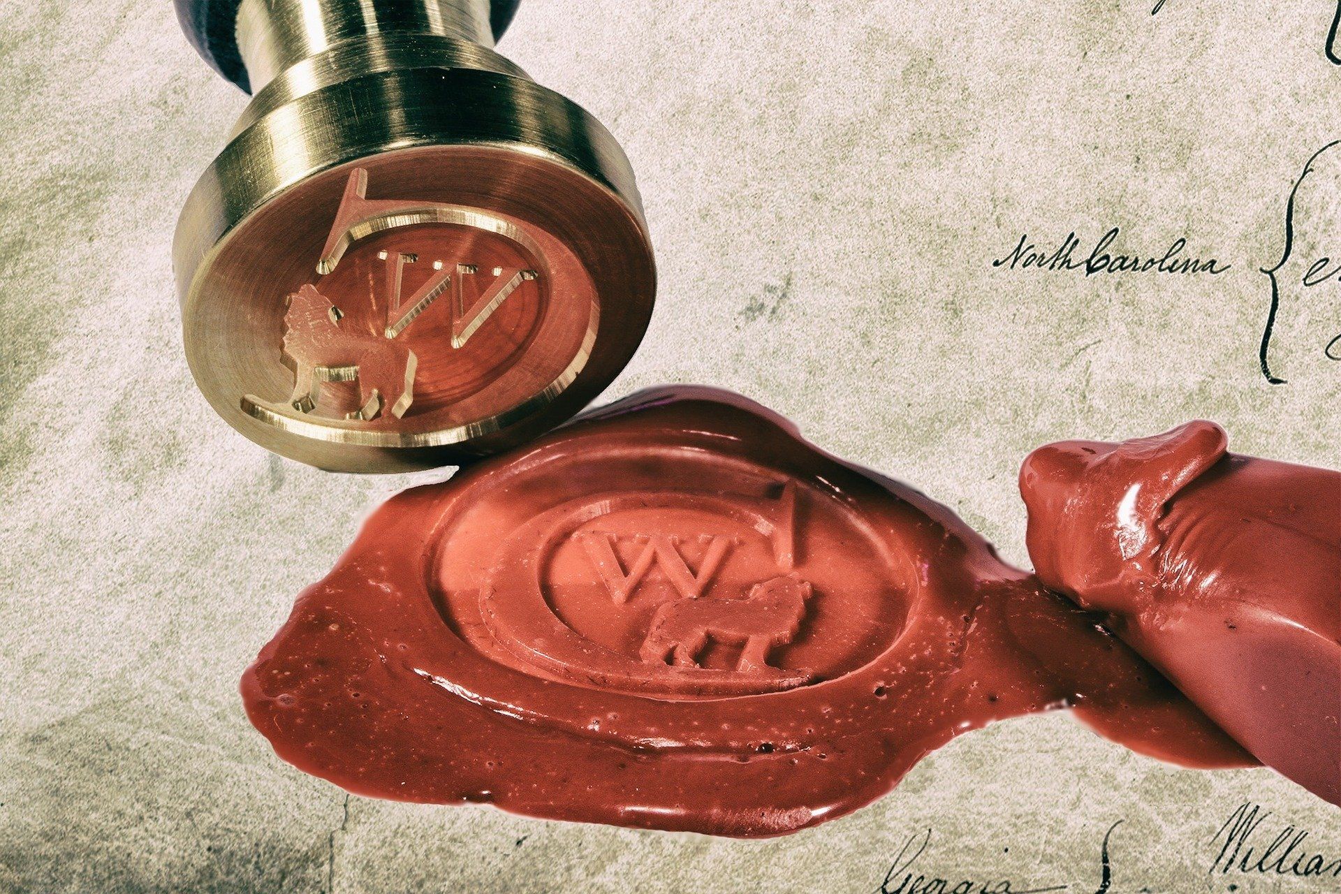 Brass seal pressing into red wax, creating an oval seal with a 