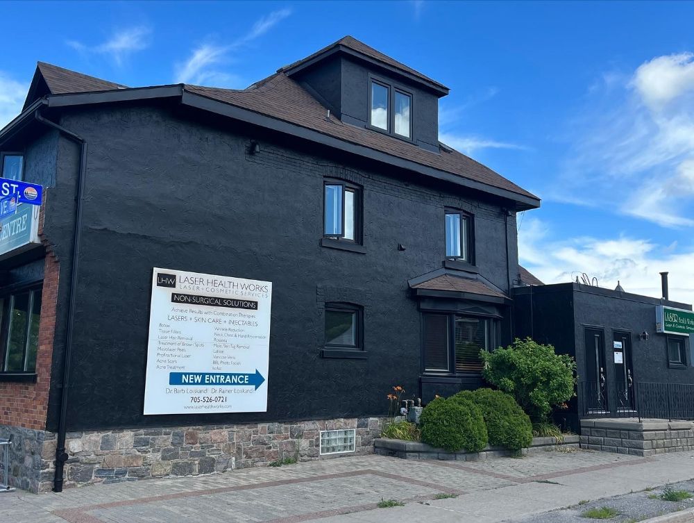 A black building with a sign on the side that says ' pharmacy '