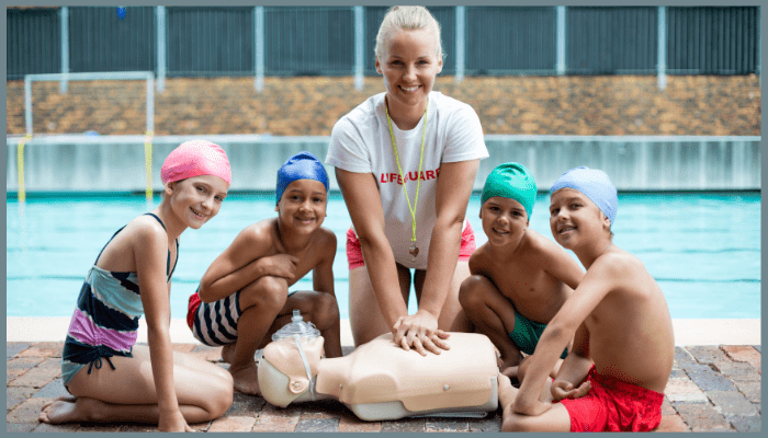 Lifeguard teaching children CPR poolside as part of water safety and prevention strategies in Canberra ACT