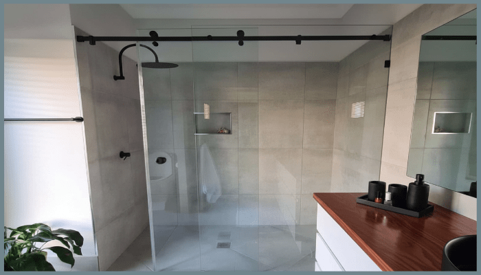 Modern Canberra bathroom featuring a frameless glass shower with matte black fittings and tiled walls
