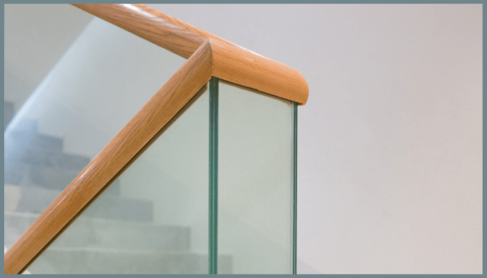 Glass balustrade staircase with sleek timber handrail showcasing modern design in a Canberra home.