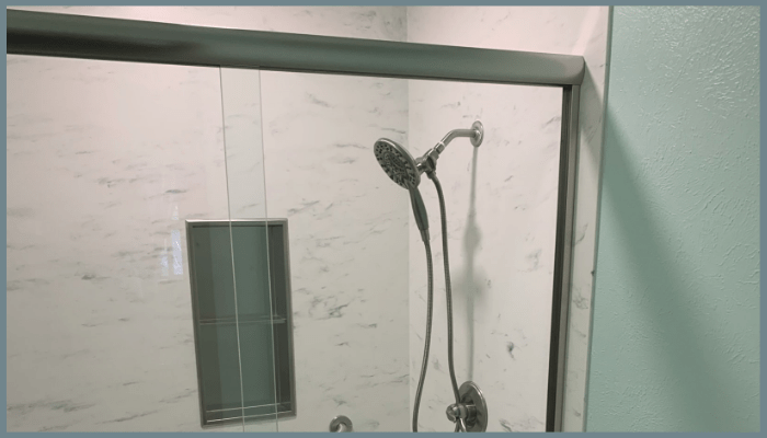 Close-up of a sliding shower door rail and glass panel.