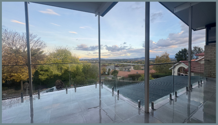 Modern balcony with standoff glass balustrade overlooking Canberra suburb and open sky view