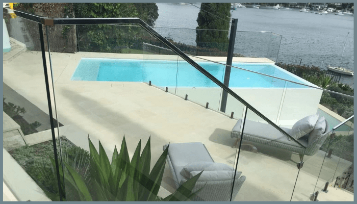 frameless standoff glass balustrades around a pool and outdoor steps