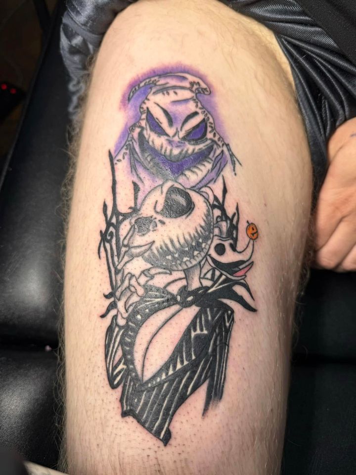 Black-and-purple tattoo of a hooded skull, floral face, and leaf-like shapes on skin