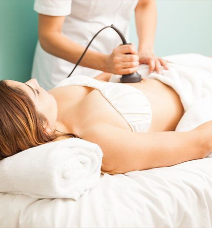 A person receiving an abdominal ultrasound examination on a treatment table.
