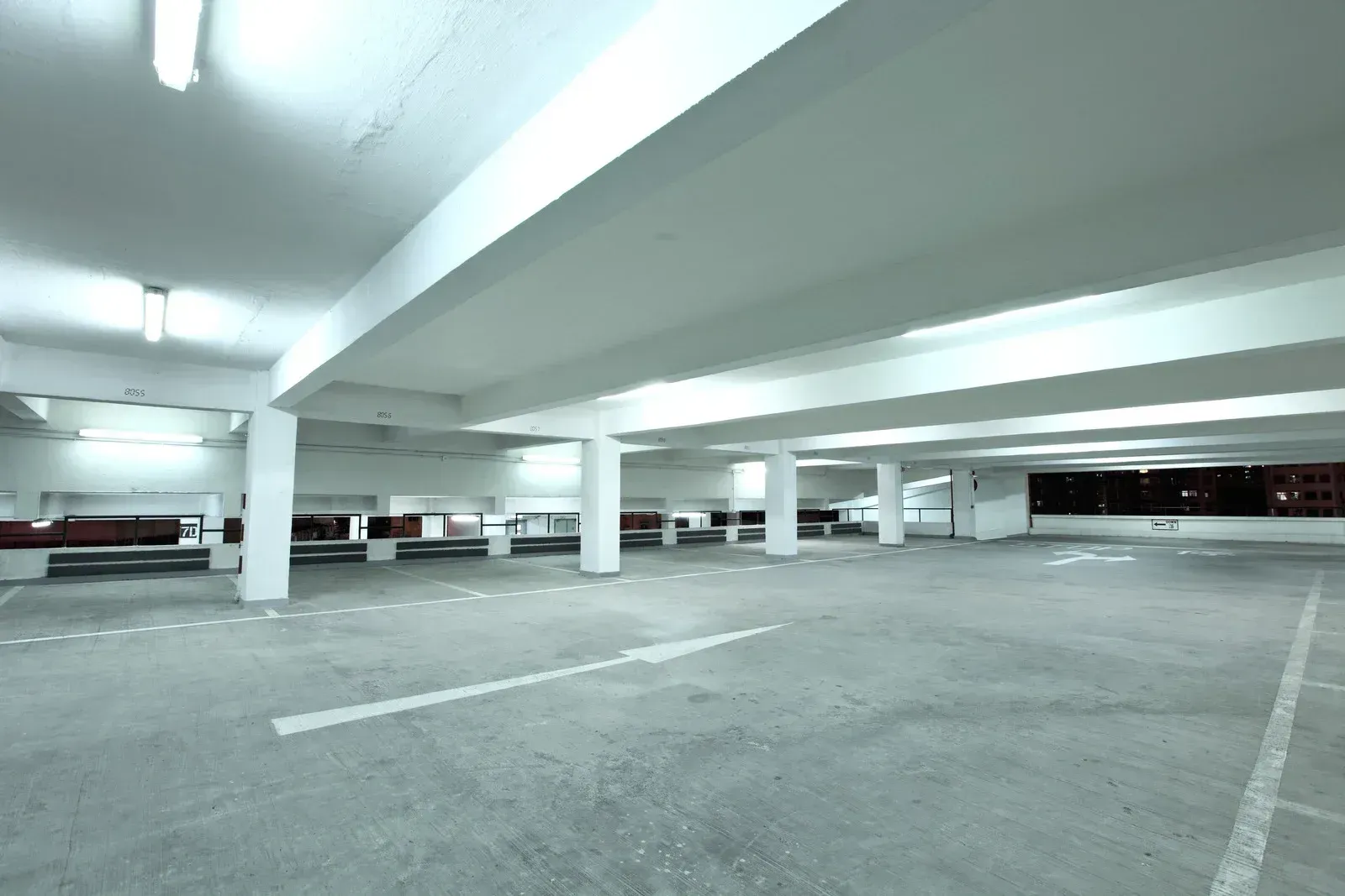 An empty parking garage with a white arrow pointing to the right