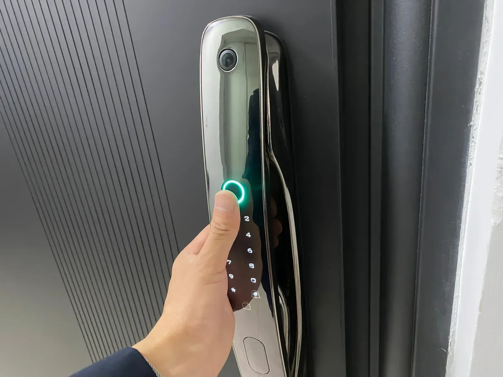 A person is pressing a button on a door lock.