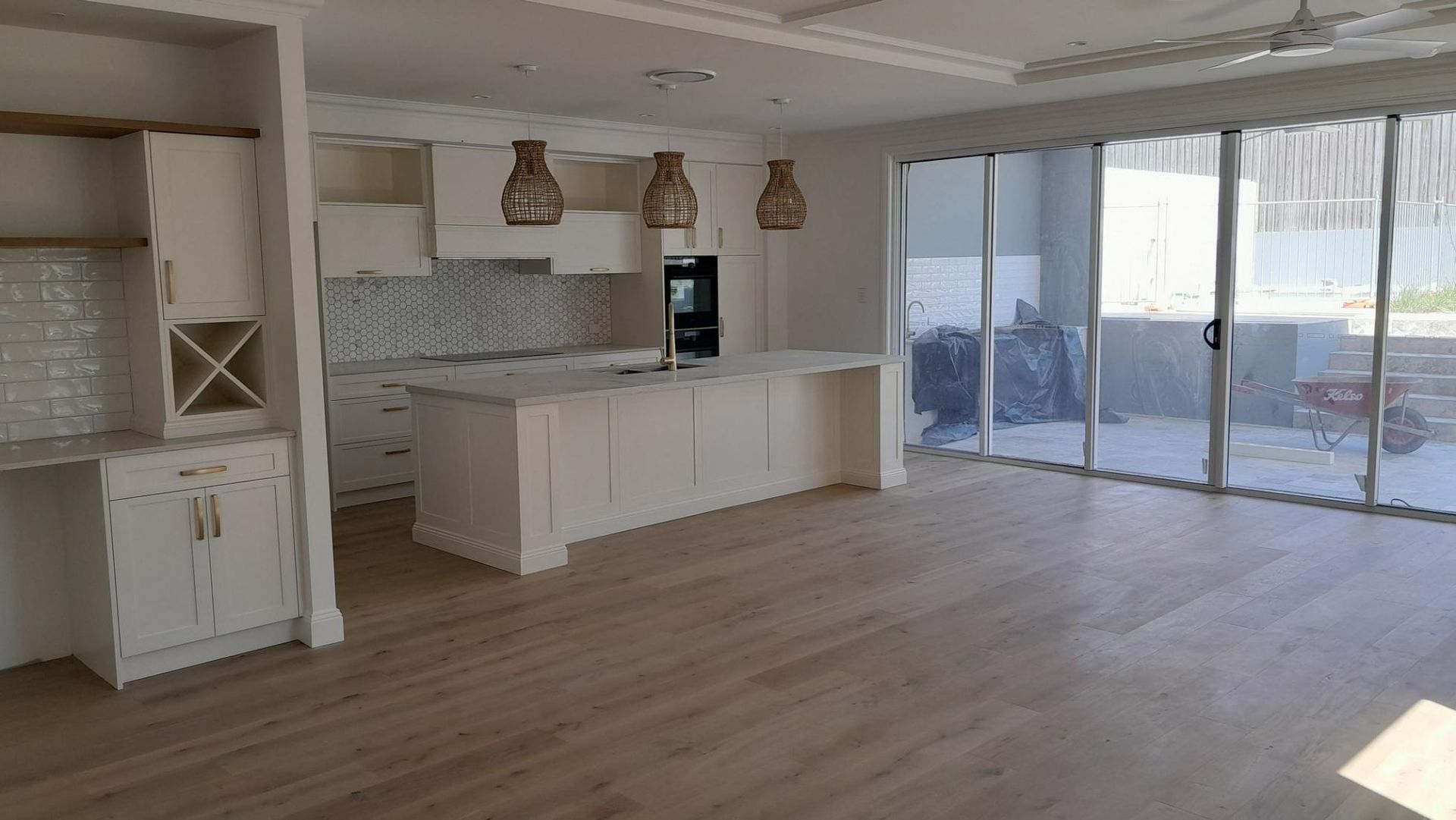 An Empty Kitchen with White Cabinets and Sliding Glass Doors — Nano2go in Birtinya, QLD