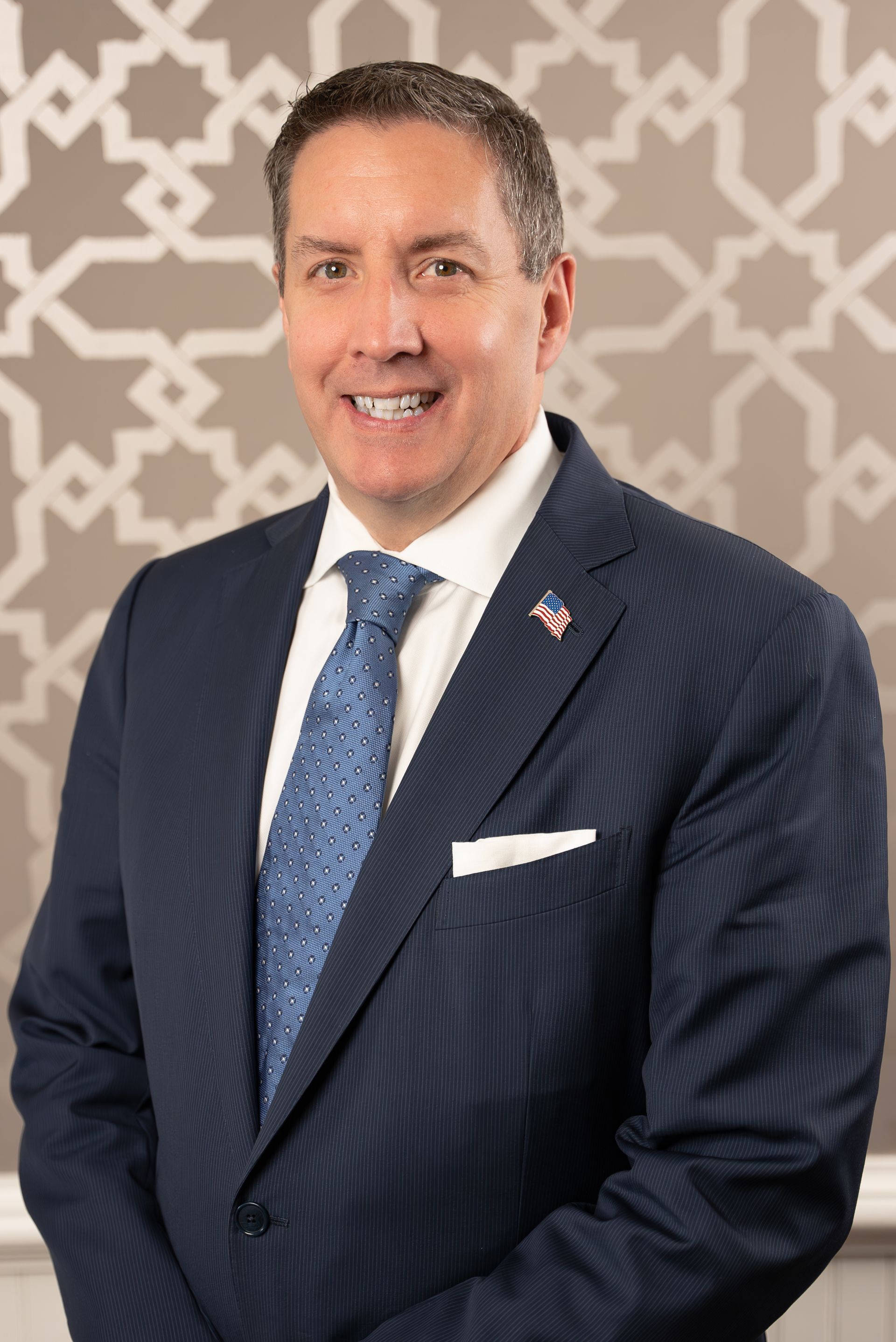 A man in a suit and tie is smiling for the camera.