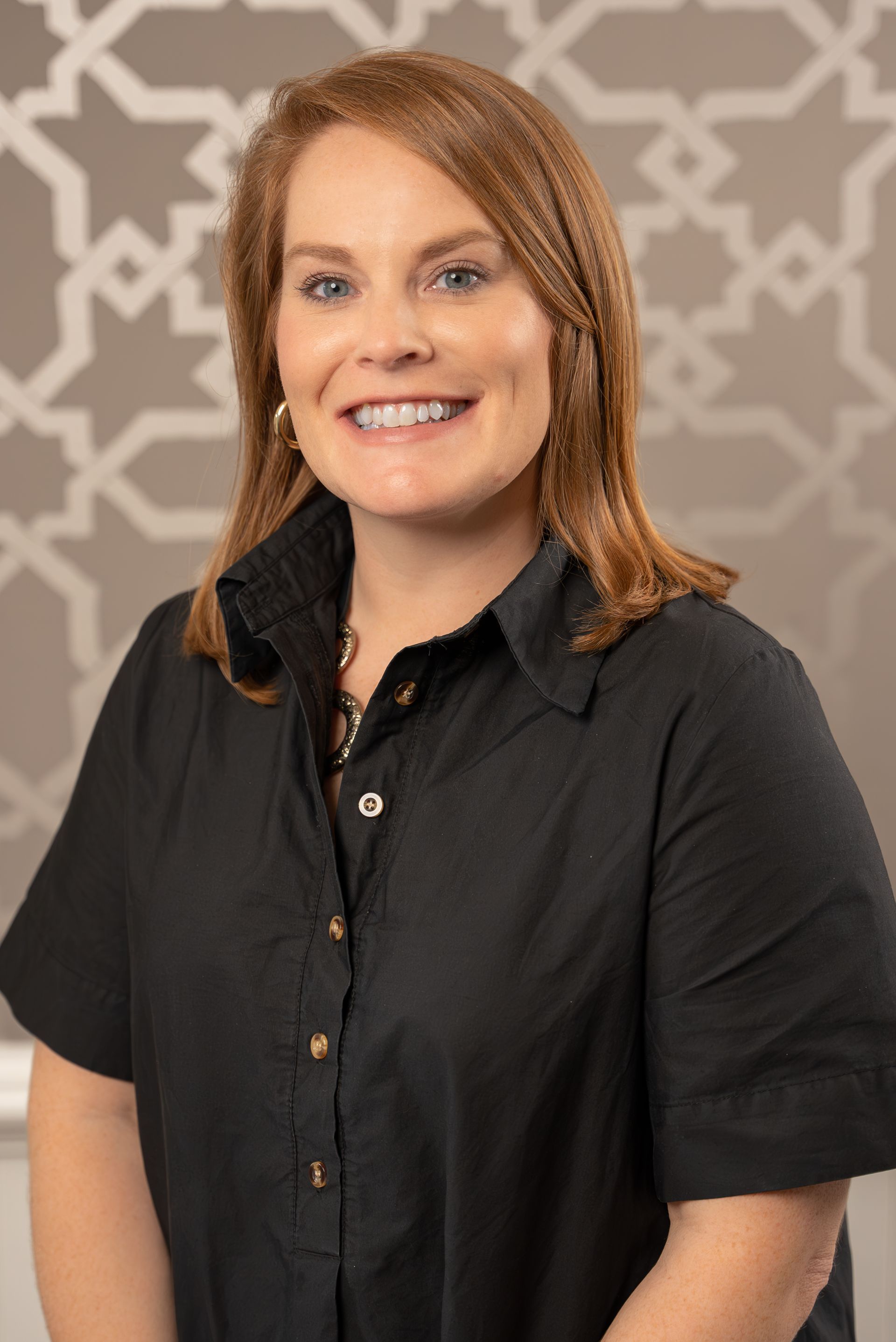 The woman is wearing a black shirt and smiling for the camera.
