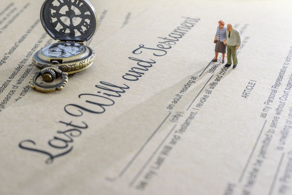 A pocket watch is sitting on top of a last will and testament.