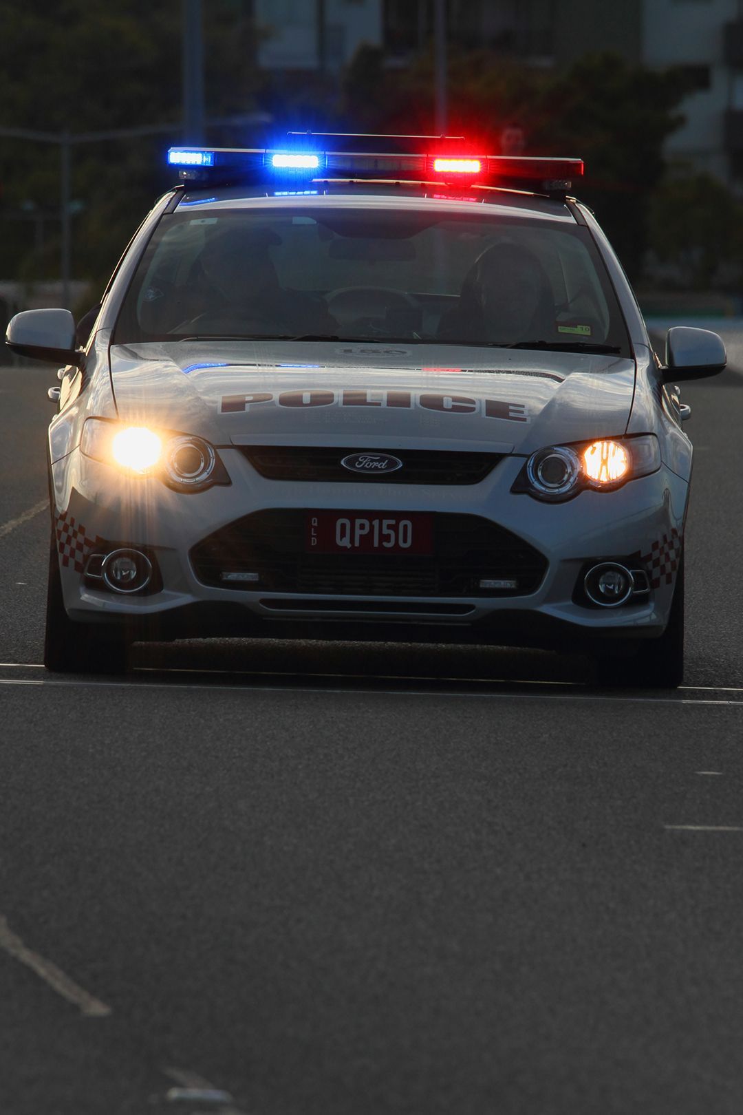 Police Car Driving With Headlights On - Queensland Lawyers in Cairns QLD