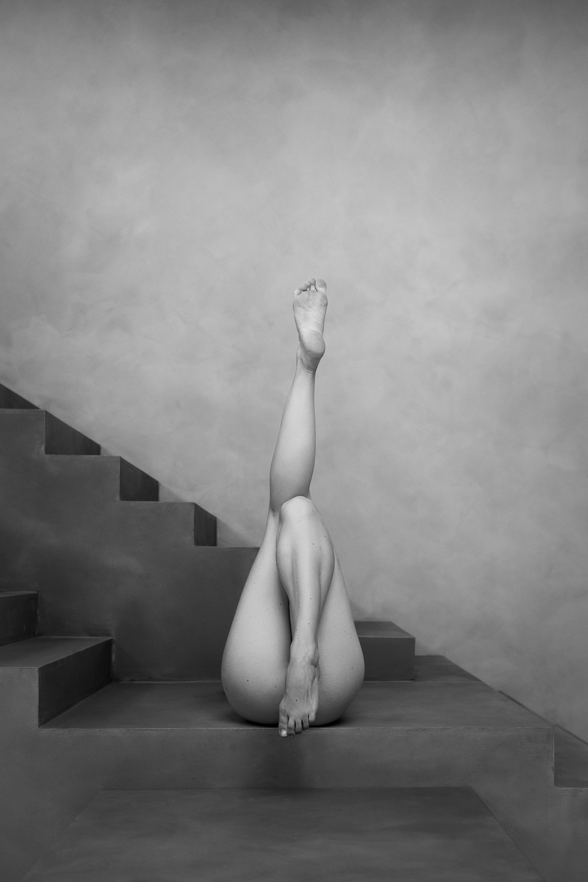 Een persoon ligt ondersteboven op betonnen trappen, met de benen gestrekt naar de bovenkant van het frame.