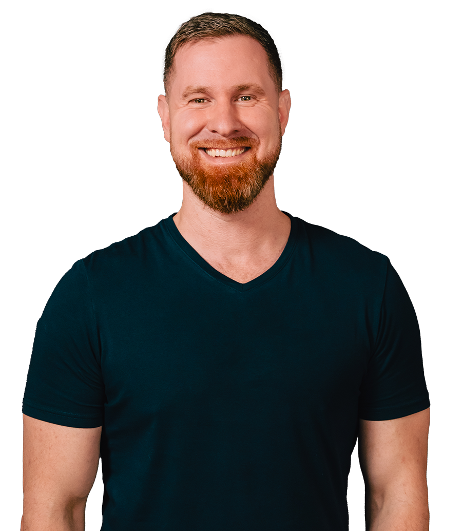 A man with a beard is wearing a blue shirt and smiling.